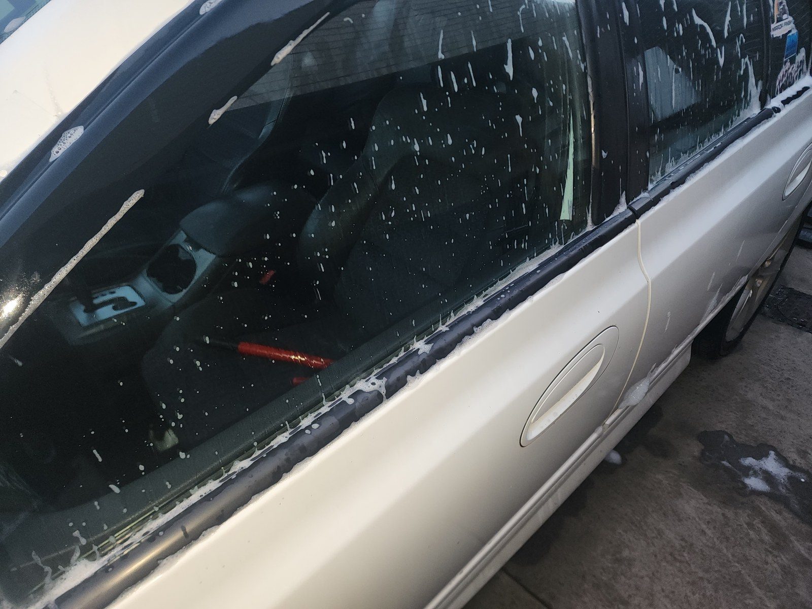 Snow foam wash on a gold sedan